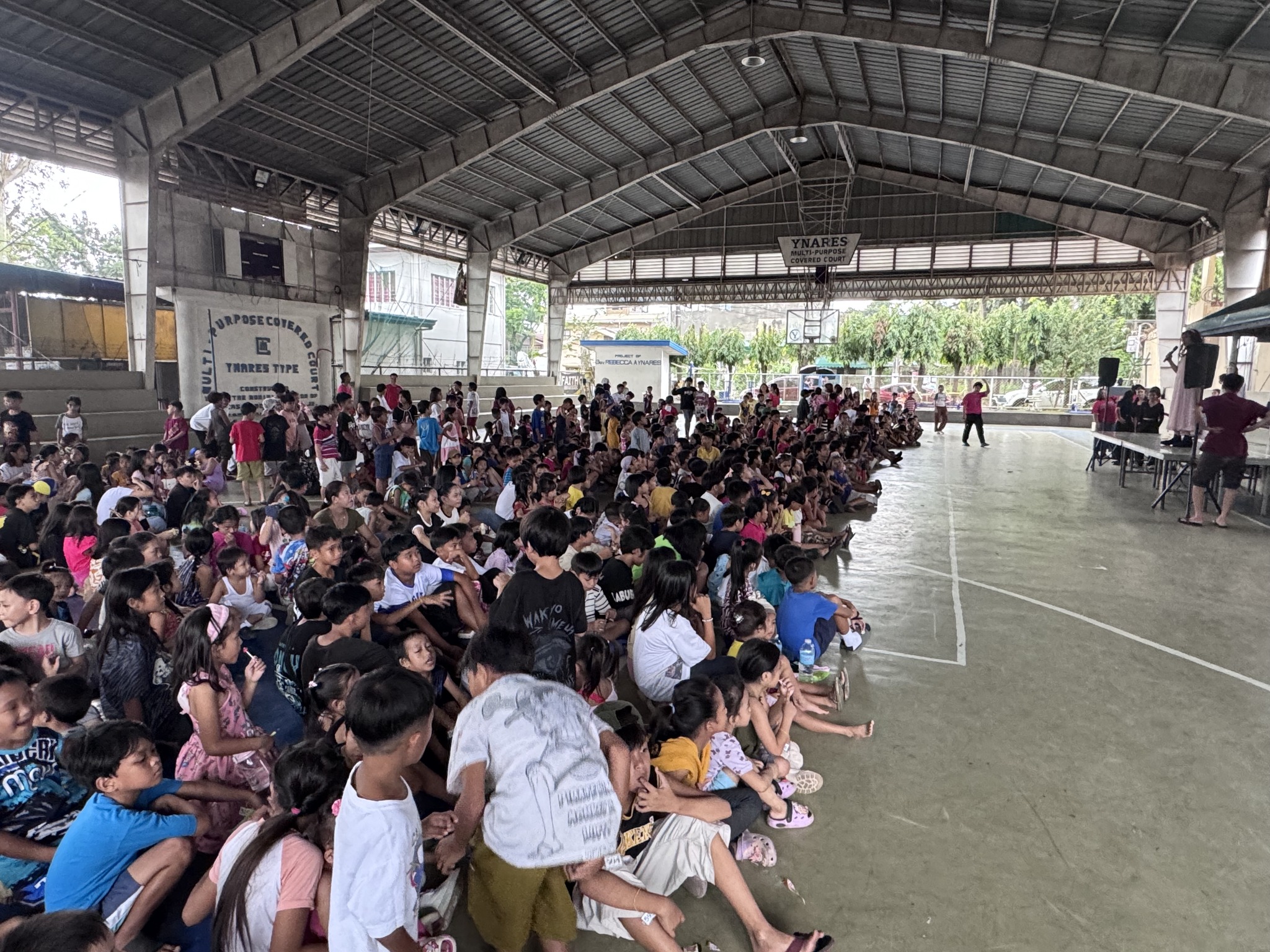 Hundreds of children seated and watching attentively at the Ynares Multi-Purpose Covered Court