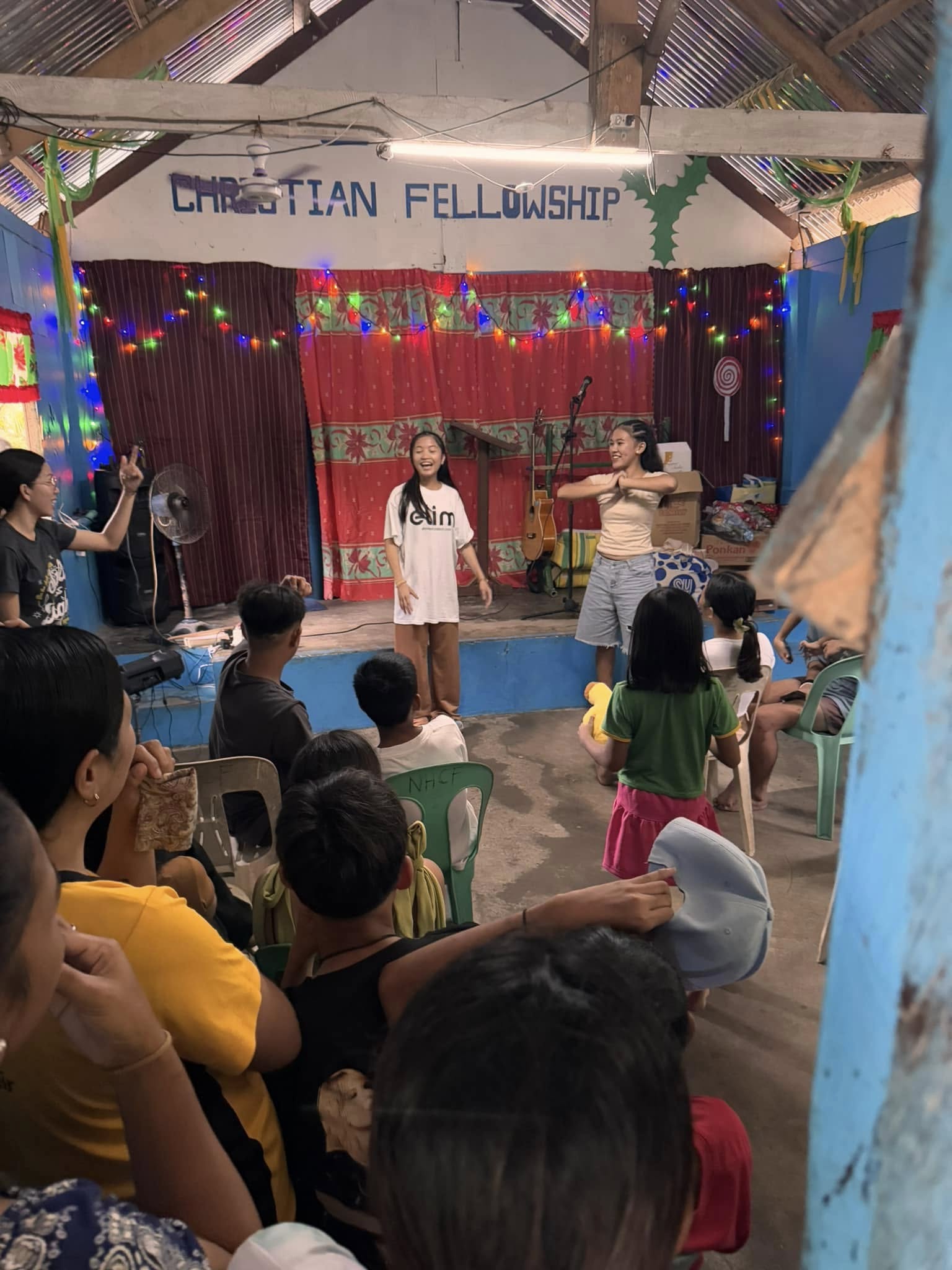 Young women leading worship on stage at New Hope Pitogo