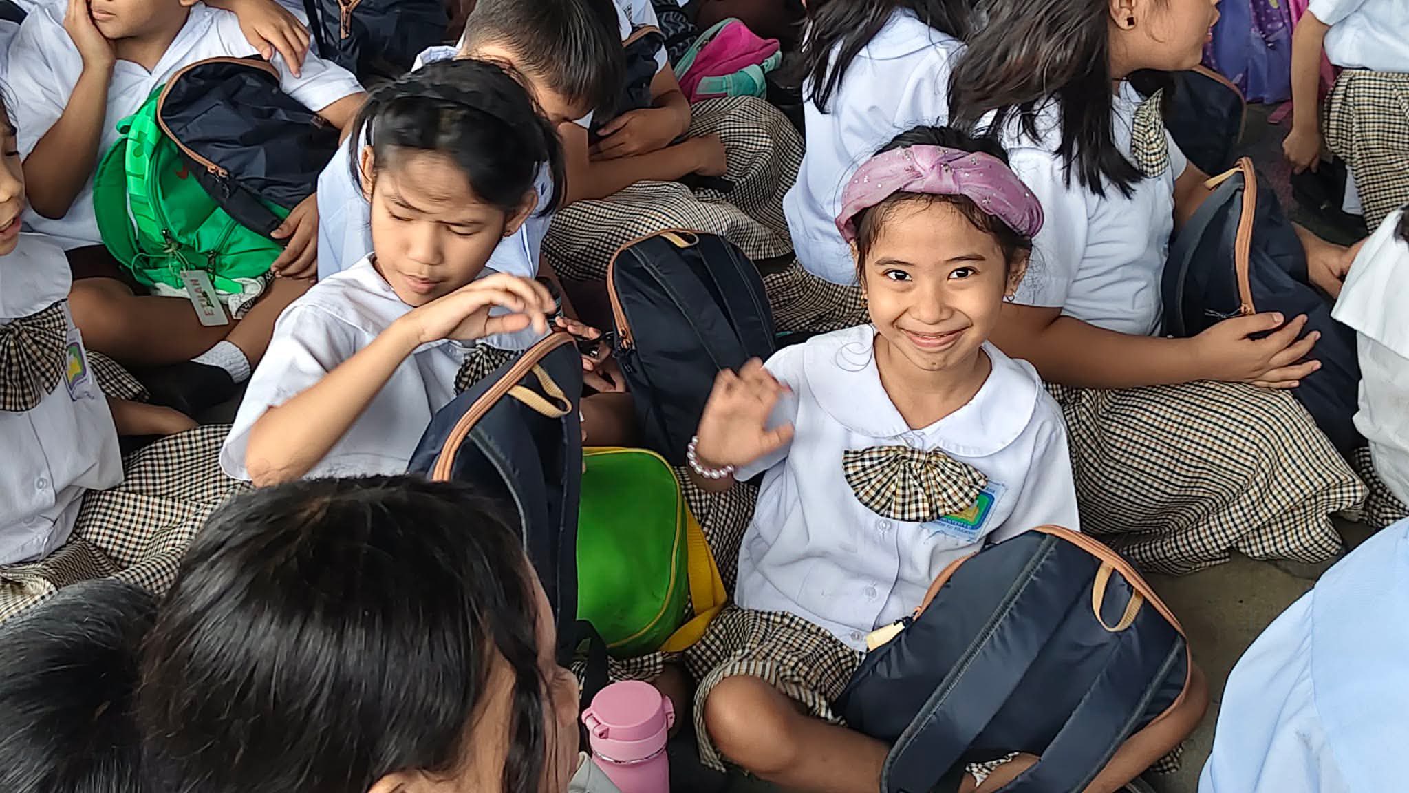 A smiling student with her new backpack at the outreach event