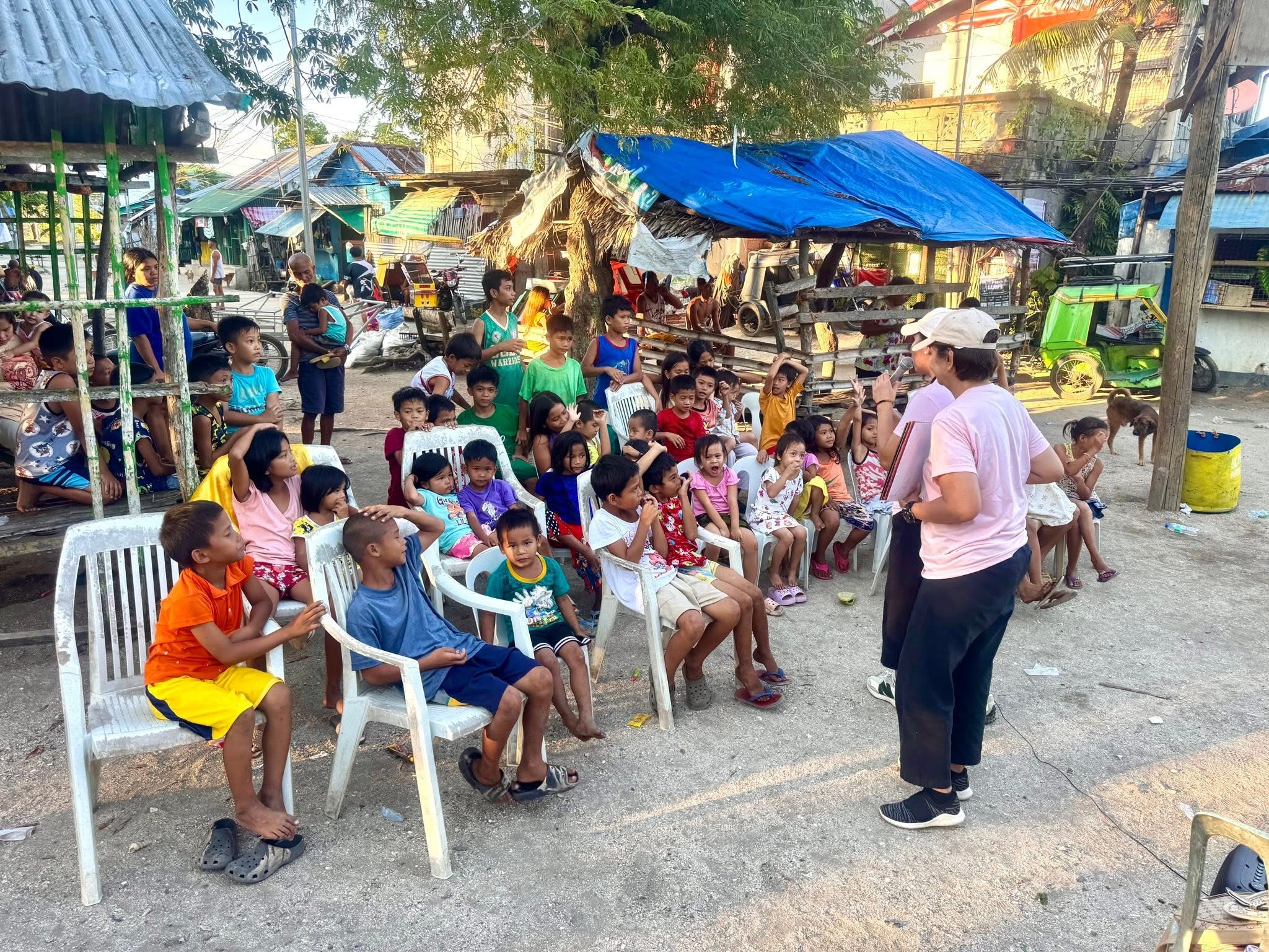 Children in a Masbate community listen attentively as a teacher shares the story of Jesus during a Superkids Bible Club