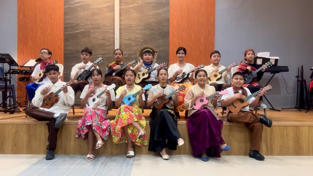 NHTA Christian School Grade 6 students in Filipiniana attire performing Tribes with colorful ukuleles during Thank You Sunday 2026