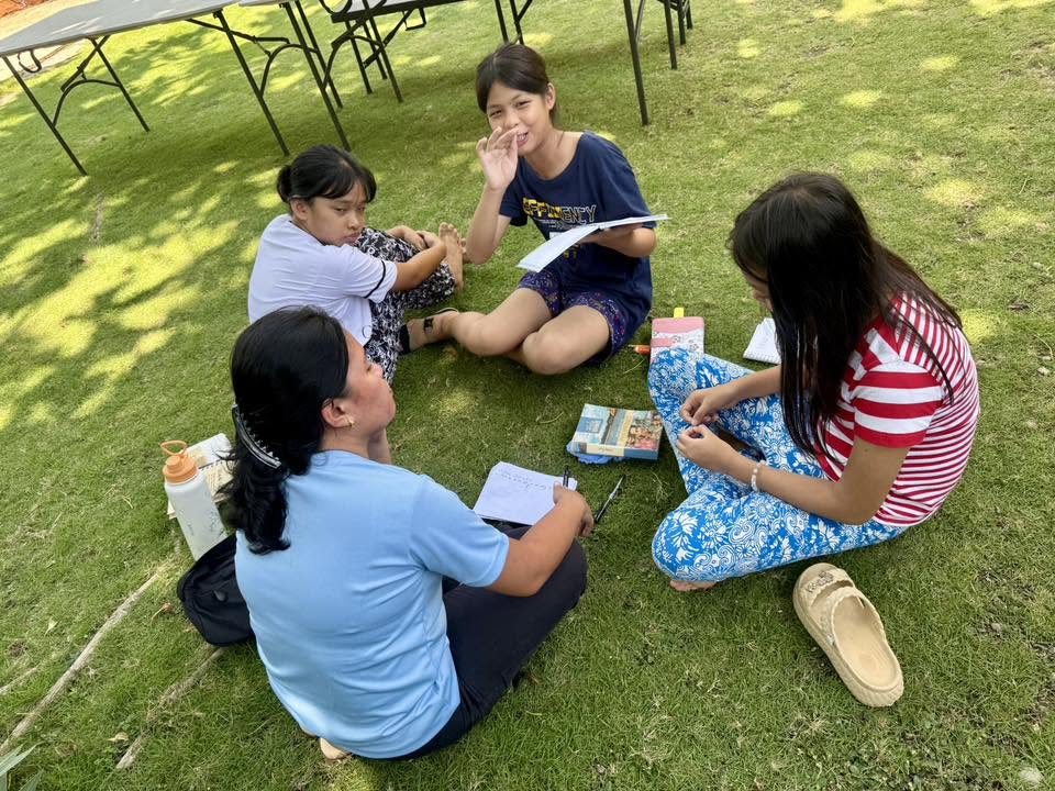 Camp teams painting their banners — Glorifiers, Glory Bound, Purpose, and 4 Peace — during a team-building session at NHTA Youth Camp 2026